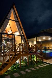 a house with a wooden railing and a deck at night at Cabana Escandinávia Praia de Fora in Palhoça +8 photos