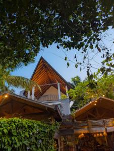 a house with a pointed roof and some bushes at White Tree Apartment in Bentota +14 photos