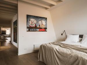 a bedroom with a bed and a painting on the wall at Strandhotel Domburg in Domburg