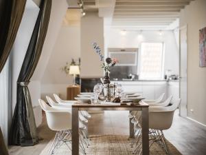 a dining room with a wooden table and white chairs at Strandhotel Domburg in Domburg