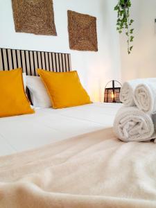 a bed with white sheets and yellow pillows at Easy4Stay in Portimão