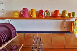 a shelf with colorful plates and bowls on it at Casa Estrella, Ferienhaus in Las Manchas in Las Manchas +6 photos