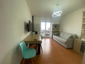 a living room with a couch and a desk and a table at La casa sul lago blu in Domaso