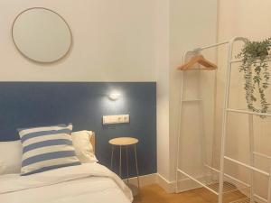 a bedroom with a bed with a mirror and a stool at Bosko Etxea Apartamentos in Bilbao