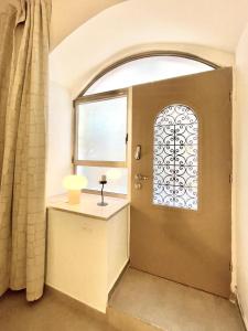 a room with a window and a table with a lamp at Nachlaot Gem - Bright, Central and Cozy in Jerusalem