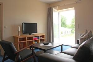 a living room with a couch and a tv and a table at Am Wiesenblick 2 Pers in Röbel