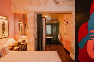 a room with a bed and a hallway with a bathroom at Hôtel Amour Paris in Paris