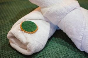 a white towel with a green button on it at Pheasant Lodge in Little Bytham +30 photos