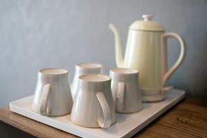 a shelf with vases and a tea kettle on it at Kag R大濠1 in Fukuoka