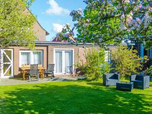 a garden with a table and chairs in the grass at Pension Feuerschiff in Borkum