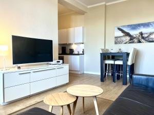 a living room with a tv and a couch and a table at Apartment Traveblick in Lübeck