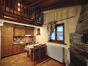 a kitchen with a table and a stove and a window at Residence Les Myosotis in Champoluc