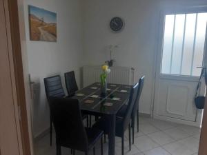 a dining room table with chairs and a vase with flowers on it at Vacation Home in Myrina