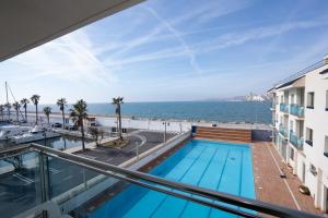 a view of the ocean from the balcony of a building at Hotel Port Sitges in Sitges