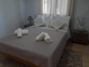 a bedroom with a bed with two rolled towels on it at Vacation Home in Myrina
