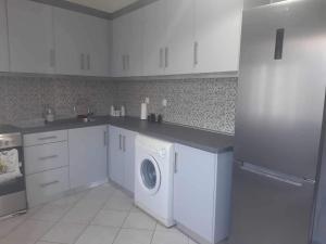 a white kitchen with a washer and dryer in it at Vacation Home in Myrina +3 photos