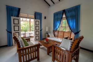a living room with a couch and chairs and a table at Villa Shanthi in Dharga Town