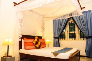 a bedroom with a canopy bed and a window at Villa Shanthi in Dharga Town +34 photos