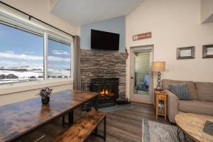 a living room with a fireplace and a couch at Summit Unit 1303 in Granby