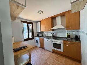 a kitchen with wooden cabinets and white appliances at Casa Miradell in Hoz de Jaca