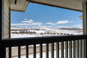 a window view of a snowy field from a house at Summit Unit 1303 in Granby