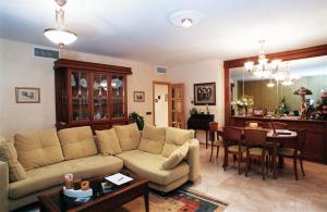 a living room with a couch and a dining room at Hotel Port Sitges in Sitges