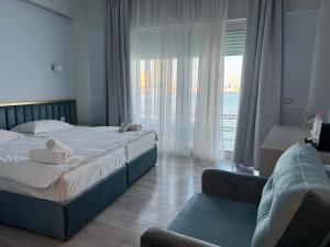 a bedroom with two beds and a couch and a window at Ventus Harbor Hotel in Durrës +53 photos