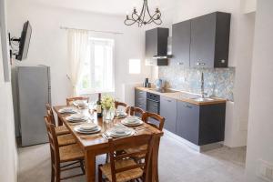 a kitchen with a wooden table with chairs and a dining room at Casa di Aonio Paleario in Colle di Val d'Elsa