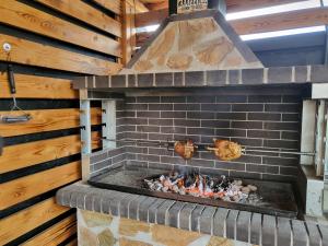 a brick fireplace with two chickens cooking on it at Holdvirág Vendégház in Jánoshalma