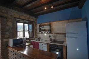 a kitchen with a white refrigerator and a microwave at Casa Rural Generosa in Tresgrandas