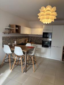 a kitchen with a wooden table and white chairs at la mer la corse in San-Nicolao