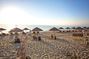 a beach with umbrellas and chairs and the ocean at la mer la corse in San-Nicolao