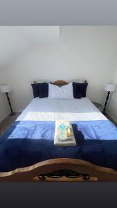 a bed with a blue blanket and a tray on it at The Cosy Cumbrian Homestay in Penrith