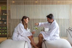 a man and a woman in white sitting in a room at Hotel Val Di Sogno - Adults Only in Malcesine