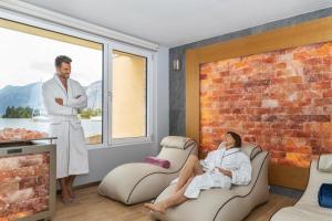 a man standing in a room with a woman sitting in chairs at Hotel Val Di Sogno - Adults Only in Malcesine