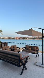 a group of couches and an umbrella next to the water at درة العروس البرادايس دور علوي عوائل فقط in Durat Alarous