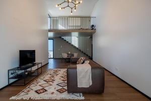 a living room with a couch and a tv at Essence Villas - Bath & Sunset in Ribeira Grande