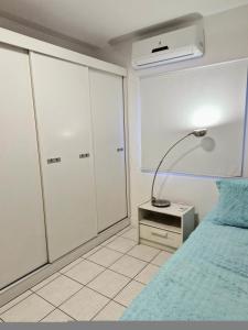 a bedroom with a bed and a lamp on a night stand at Pacífico Guest House Recife - Polo Médico e Universidades in Recife