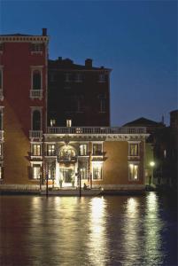 a building next to the water at night at Hotel Palazzo Barbarigo Sul Canal Grande in Venice