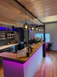 a kitchen with a bar with purple lighting at HOTEL andrä in Salzburg +21 photos