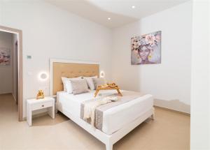 a white bedroom with a white bed and a painting at Nerida Luxury Villas in Kastéllion +136 photos