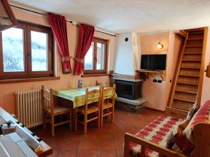 a dining room with a table and chairs and a fireplace at Residence Les Myosotis in Champoluc