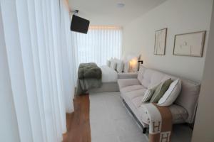 a white living room with a couch and a chair at VILLA La Finca - Privada in Vieira do Minho
