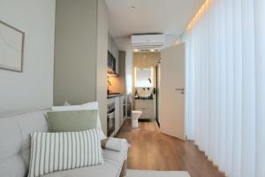 a living room with a white couch and a kitchen at VILLA La Finca - Privada in Vieira do Minho