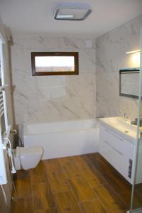 a bathroom with a tub and a toilet and a sink at Willa Kwiat Jabłoni in Mikołajki +15 photos