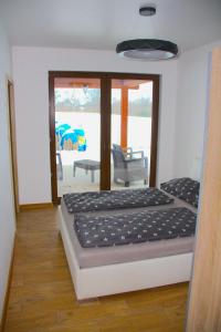 a bed in a room with a view of a patio at Willa Kwiat Jabłoni in Mikołajki