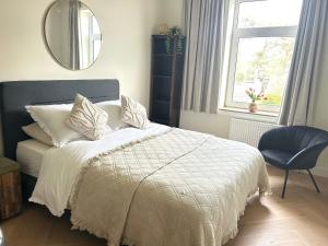 a bedroom with a bed and a mirror and a chair at Lovely Spacious Apartment in Zandvoort