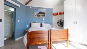 a bedroom with a bed with a blue wall at Traka Cottages in Sedgefield
