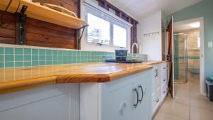 a kitchen with white cabinets and a wooden counter top at Traka Cottages in Sedgefield