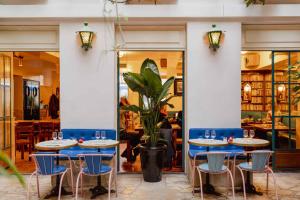 a restaurant with blue tables and chairs and a plant at Hôtel Amour Paris in Paris +34 photos
